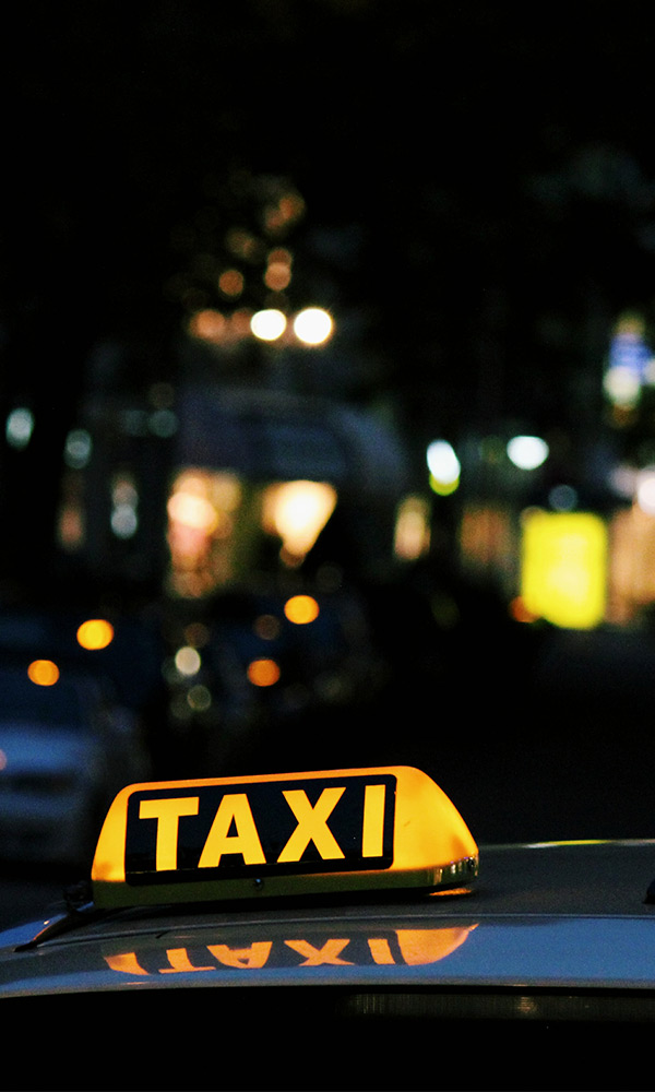 Taxi Weiss bei Nacht in der Stadt