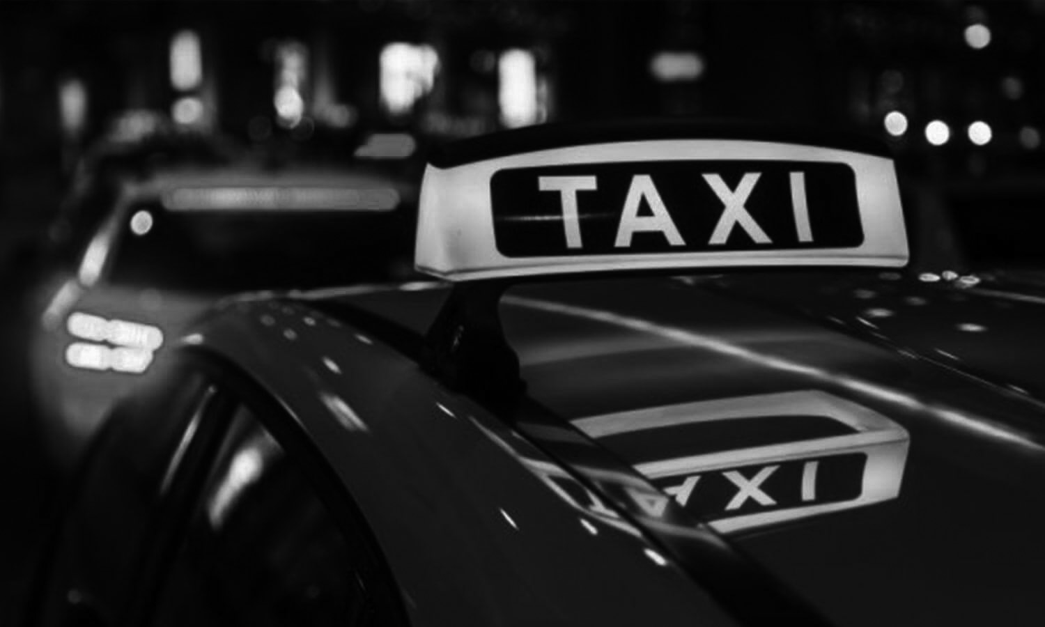 Taxi Weiss bei Nacht in der Stadt